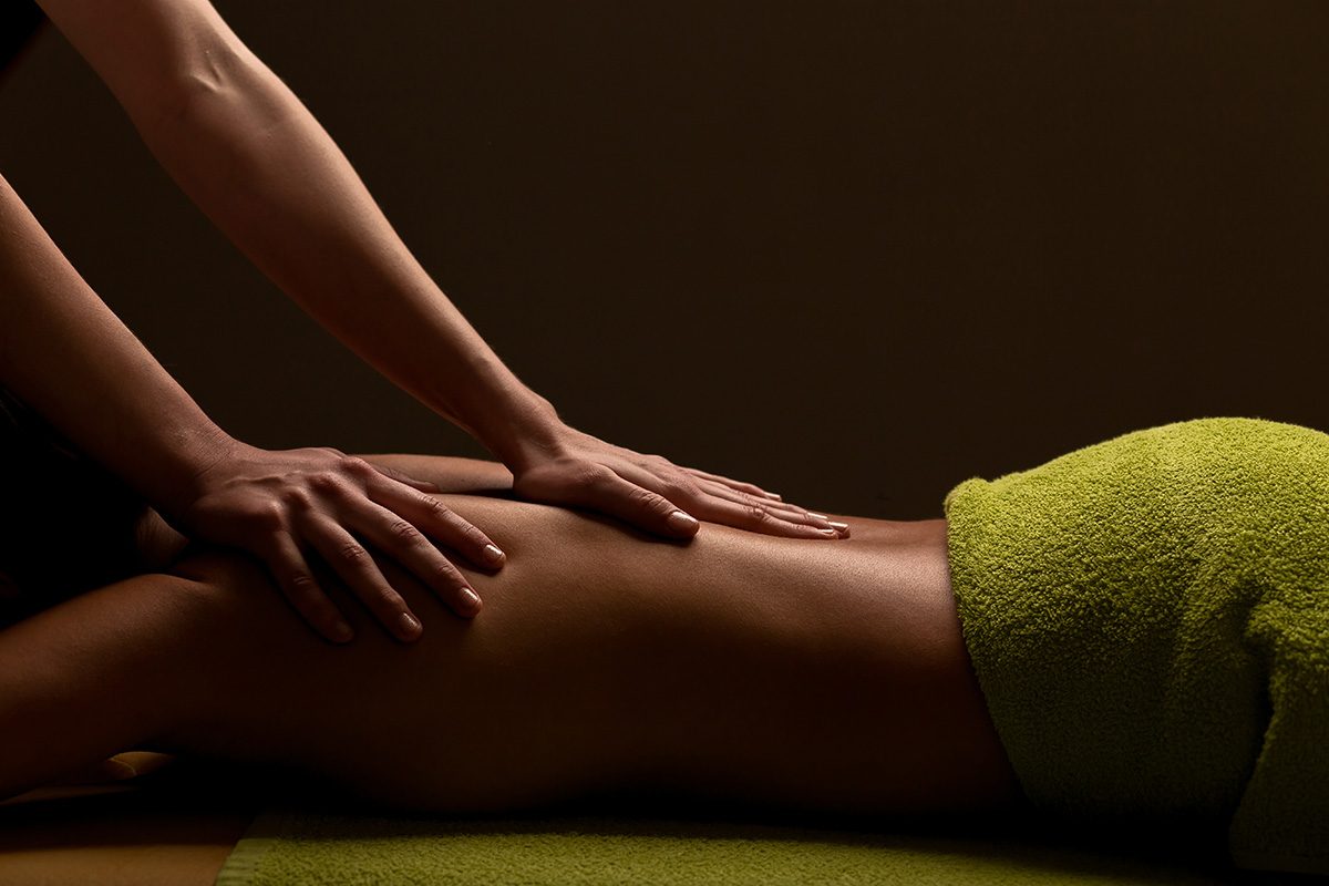 Zwei Frauenhände bei der Rückenmassage