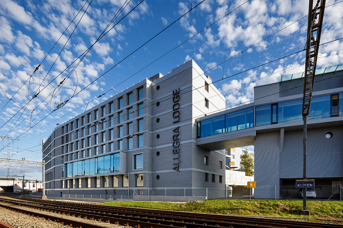 Hotelfassade im Sonnenschein von der Bahnseite aus gesehen.