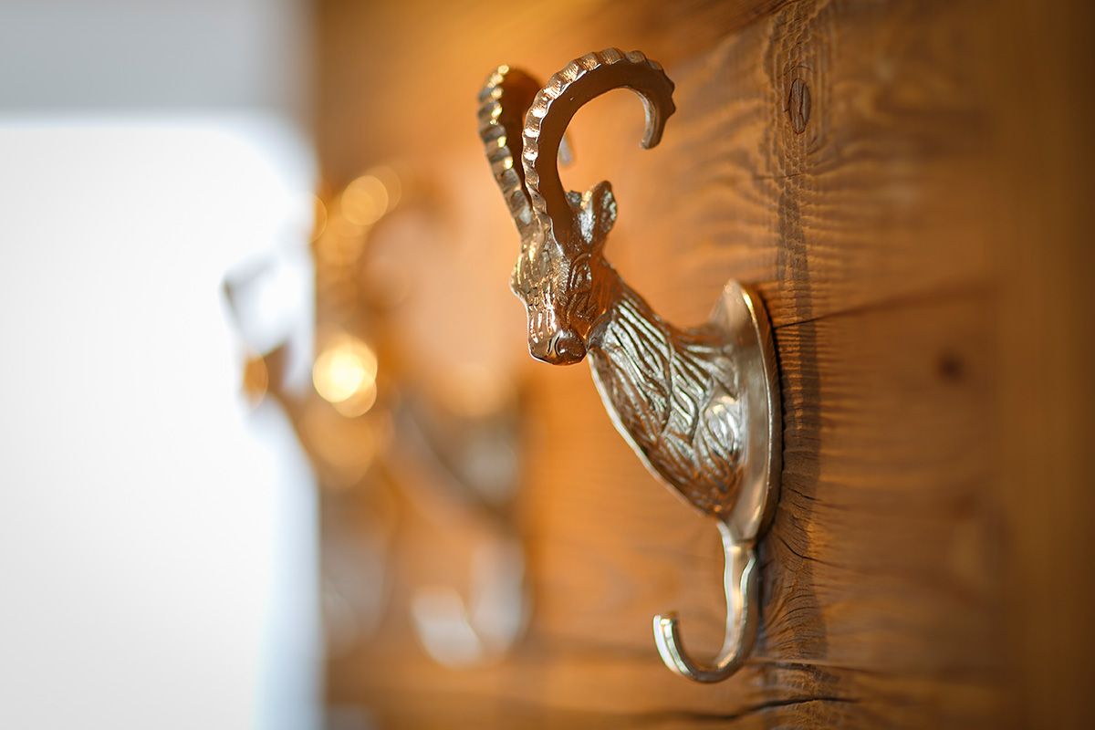 Steinbockfigut aus Metal, an einer Holzwand festgemacht und in einem Hotelzimmer der Allegra Lodge präsentiert.