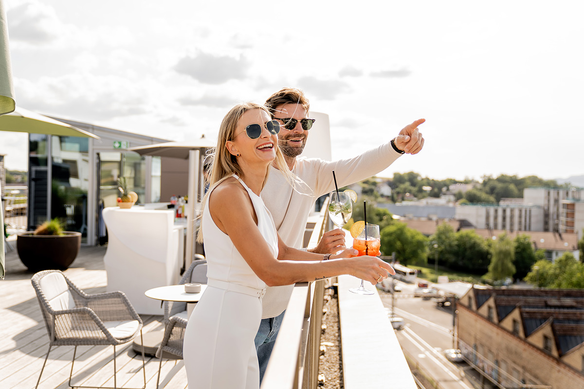 Rooftop-Erlebnis in Zürich: Paar geniesst Cocktails auf der Dachterrasse des Hotels Allegra Lodge.