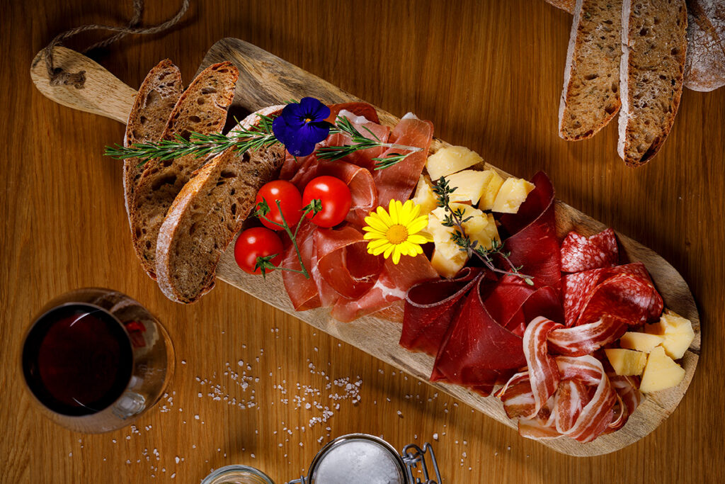 Holzbrett mit kaltem Aufschnitt und Fleisch für einen Apero.