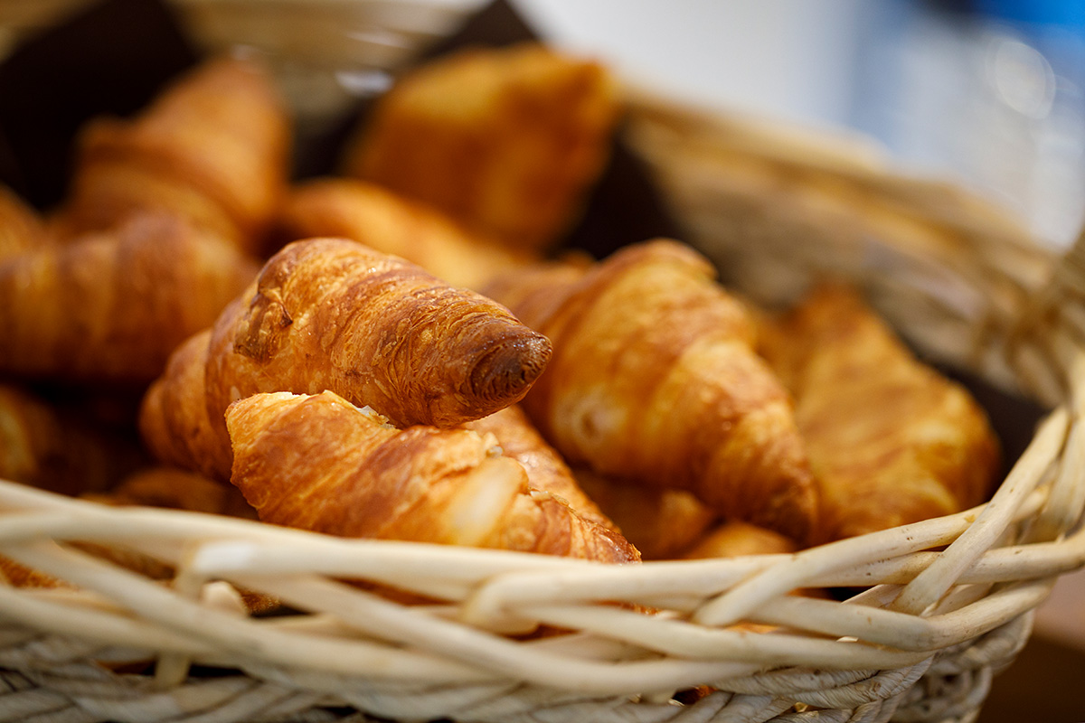 Crispy, golden-brown Swiss "Gipfeli" (croissants) in a wicker basket at the Allegra Lodge buffet.