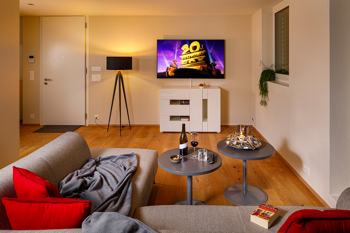 Gemeinschaftsbereich im achesa ShareLiving Kloten: Modernes Co-Living Wohnzimmer mit hochwertiger Ausstattung, Smart-TV und gemütlicher Lounge-Ecke nahe dem Flughafen Zürich.